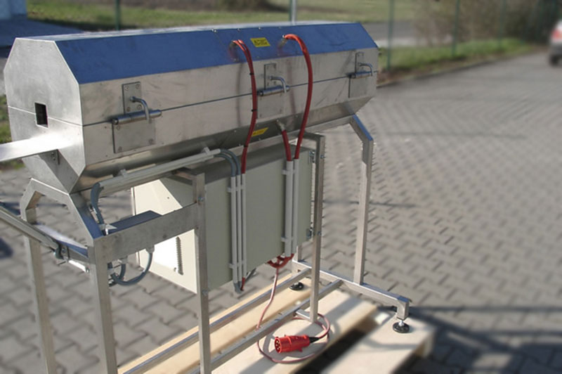 Four de transition en acier inoxydable avec un boîtier de commande en dessous et une partie supérieure à charnière pour chauffer une bande en acier sans fin